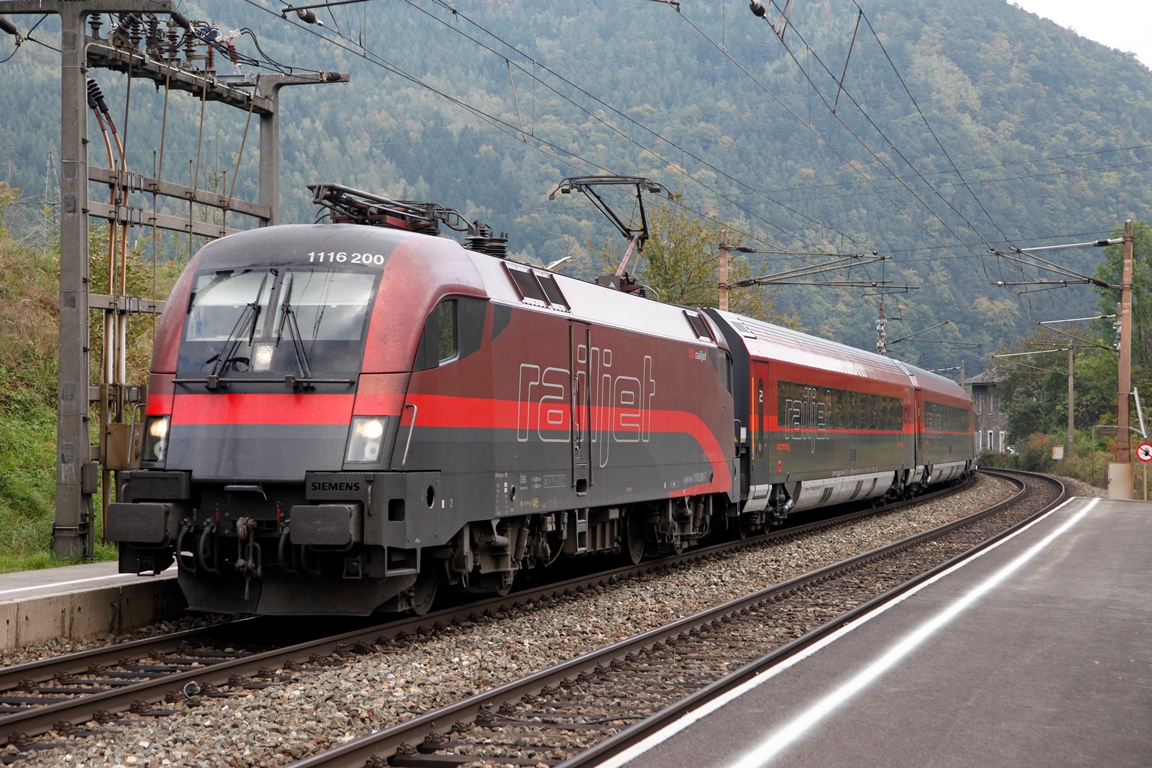 Die 1116 200 besitzt noch ihre Railjet-Versuchslackierung die sich in einigen Details von den Serienmaschinen unterscheidet. Hauptmerkmal ist der rote Streifen der auf der schwarzen Frontseite durchgezogen ist. Hier zieht die 1116.200 am 6.10.2014 einen Railjet in der Haltestelle Schlöglmühl über die Semmeringbahn.