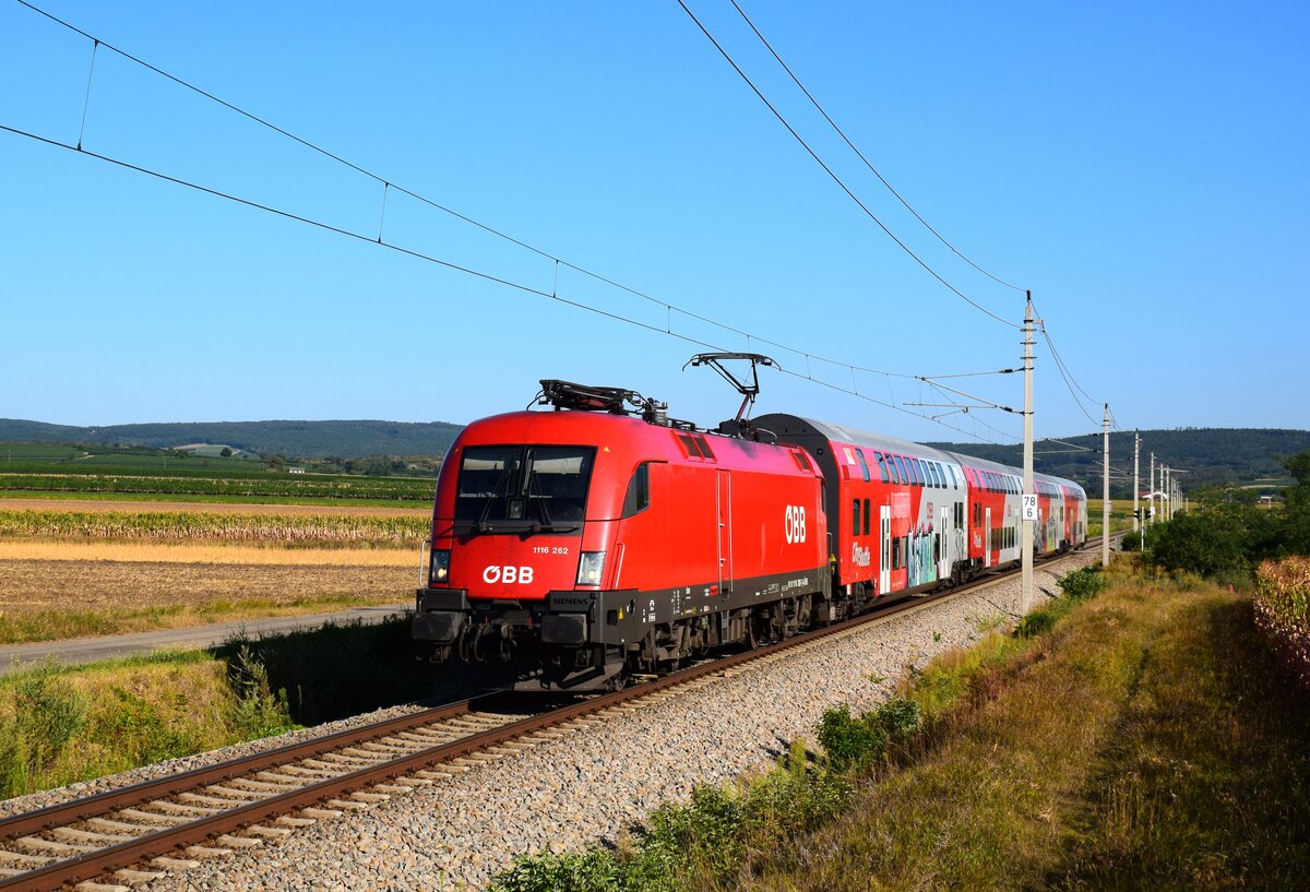 Die 1116 262 fährt mit einem Dosto Zug von Retz nach Wien kurz nach der Abfahrt aus Retz.
11.08.2024.