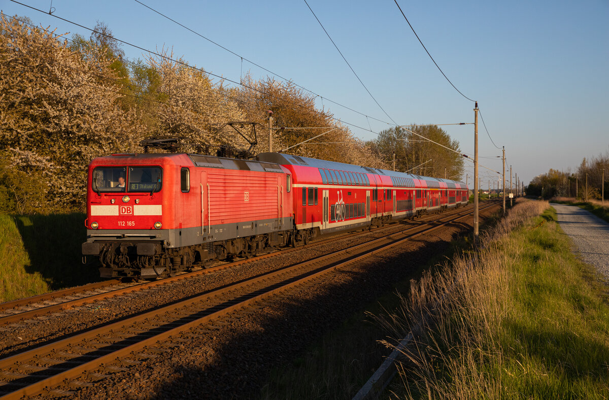 Die 112 165 zieht am 07.05.2023 den RE3 3314 von Lutherstadt Wittenberg nach Stralsund, durch Teschenhagen.
