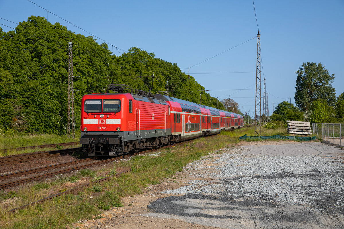 Die 112 185 rollte am 27.05.2023 mit ihrem RE3 3312 Lutherstadt Wittenberg - Stralsund, durch den Bahnhof von Miltzow.
