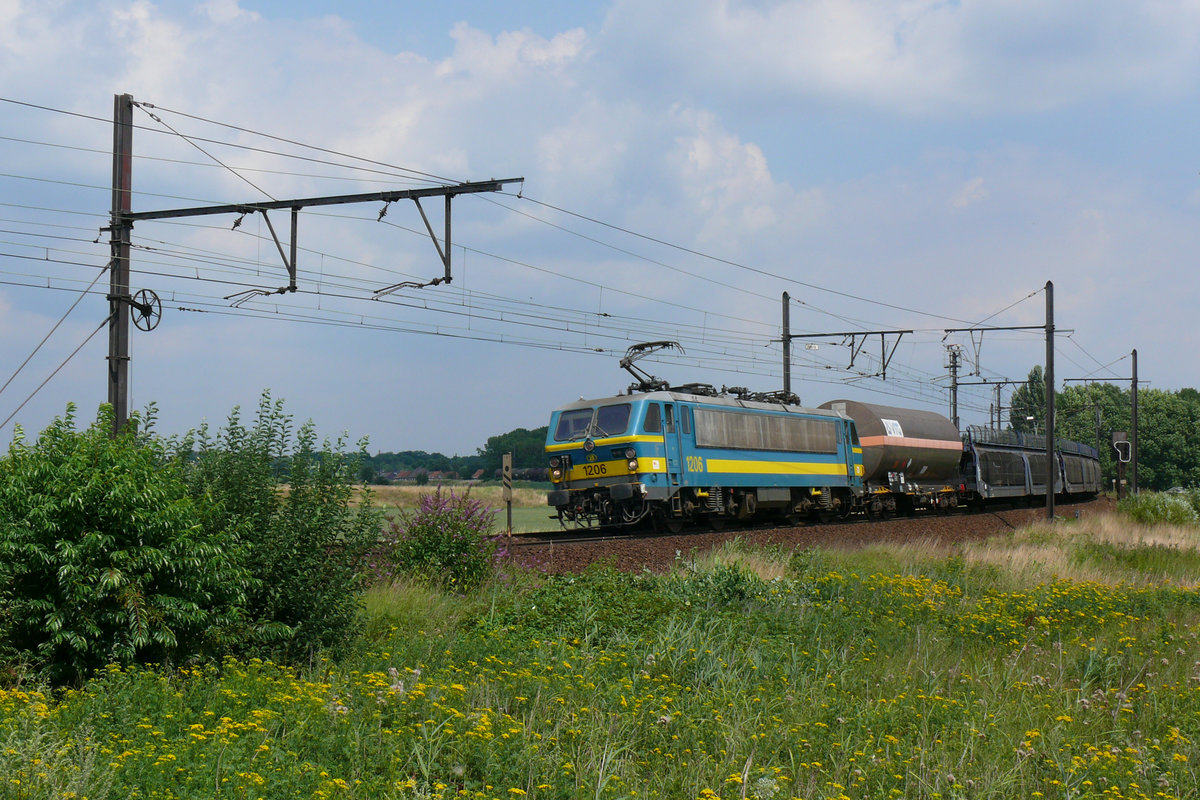 Die 1206 der SNCB/NMBS mit einem langen Güterzug im Gleisbogen bei Ekeren. Im Hintergrund erkennt man noch das Ende des Zuges. Die Aufnahme entstand am 30/07/2010.