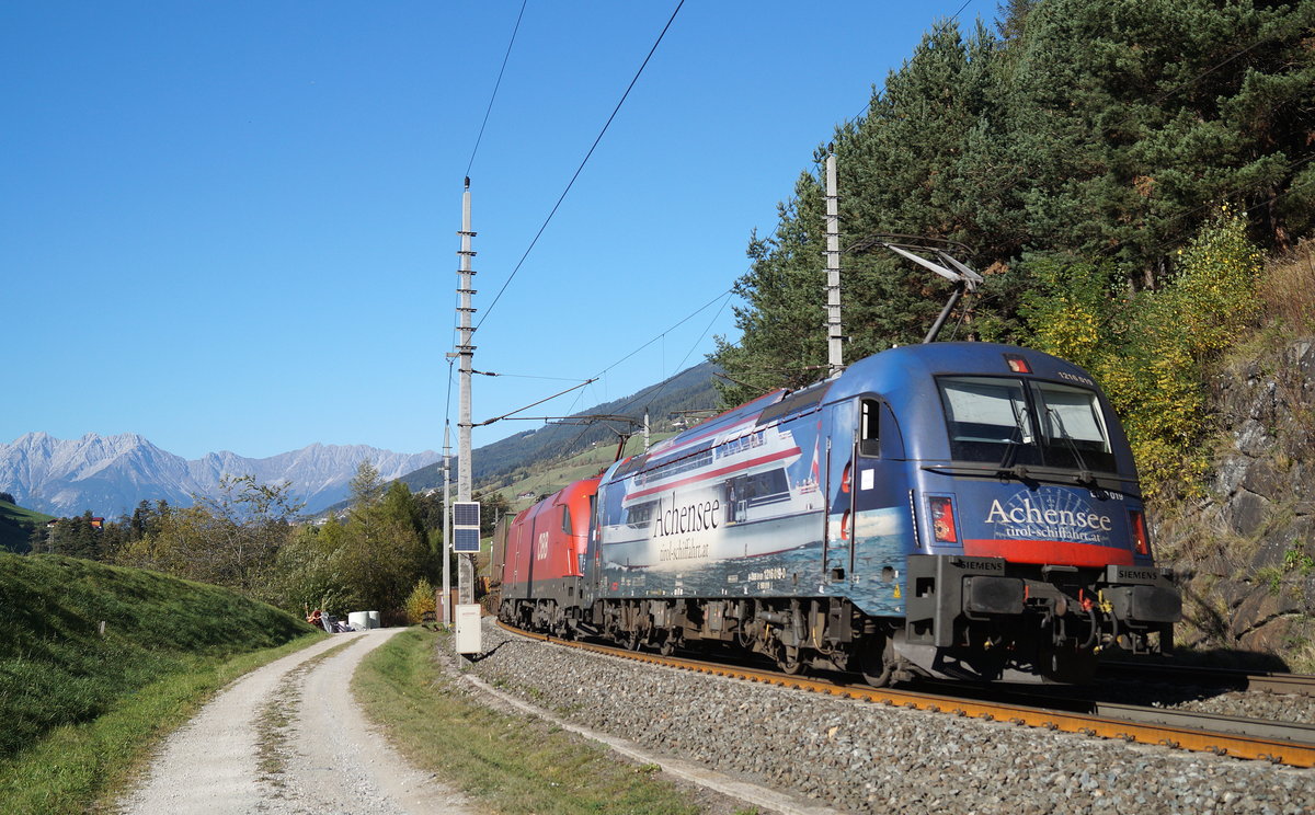 Die 1216 019  Achensee-Schifffahrt  und die 1116 161 kämpfen sich mit einem KLV-Zug bei Mühlbachl den Berg hinauf, 13.10.2018.