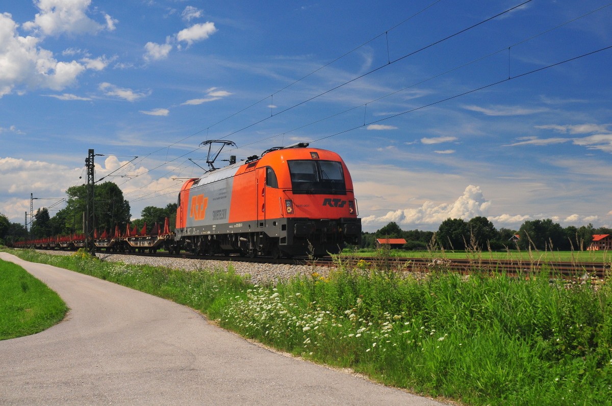 Die 1216 901-9 von RTS zieht am 02. August 2014 einen aus Flachwagen bestehenden Zug in Richtung Salzburg bei Übersee am Chiemsee. 