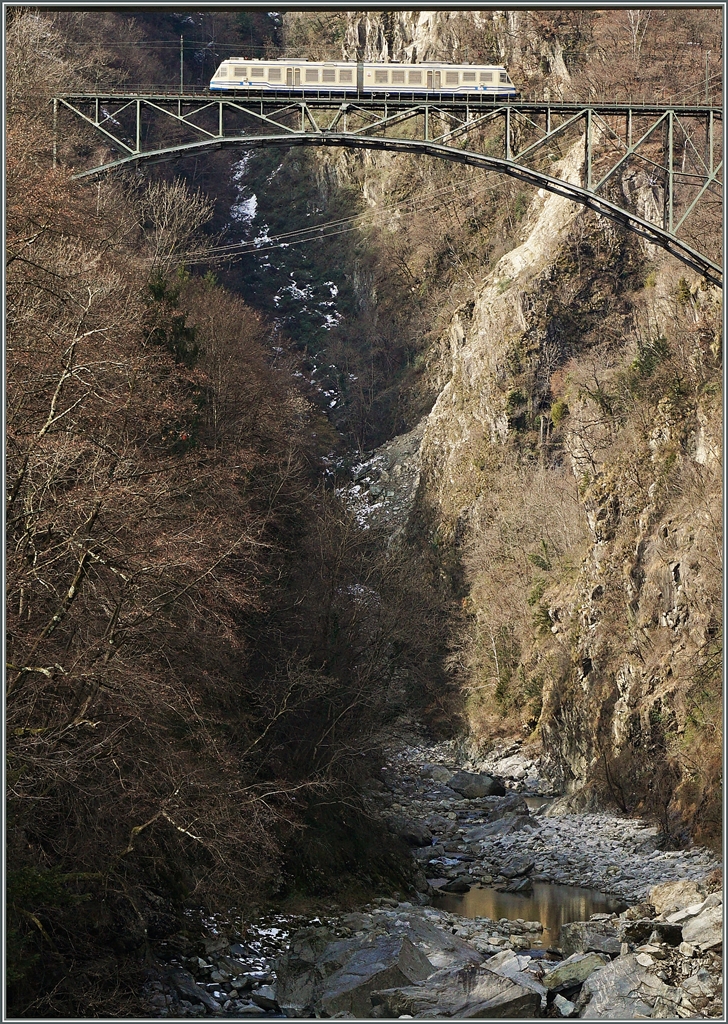 Die 132 Meter lange Isorno Brücke bei Intragna aus zwei verschiedenen Perspektiven: Auf diesem Bild vom tief eingeschnitten Tal aus; wobei die knapp nicht zu sehende Strassenbrücke kaum einen anderen Schnitt zulässt.
Auf dem Bild ist der FART ABe 4/6 52 auf der Fahrt als Regionalzug 311 von Camedo nach Locarno zu sehen. 
11. März 2016