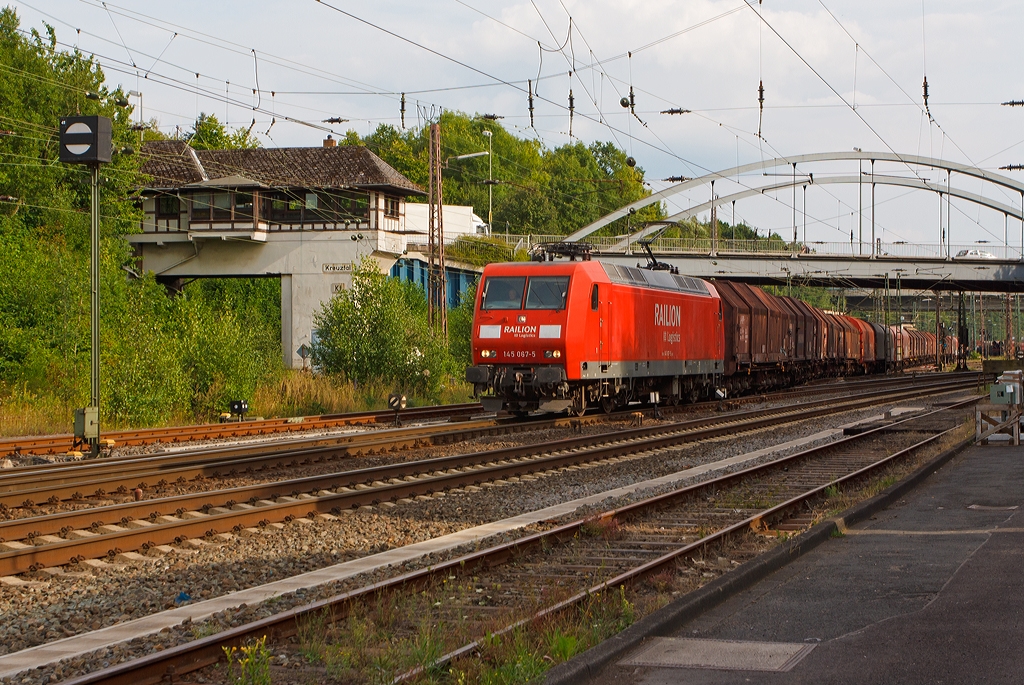 Die 145 067-5 der DB Schenker Rail verlsst am 29.08.2013 den Rangierbahnhof Kreuztal mit einem Coilzug in Richtung Hagen. 
Die Lok wurde im Jahr 2000 bei ADtranz in Kassel unter der Fabriknummer 33391 gebaut.
Im Hintergrund das 1923 gebaute Reiterstellwerk Kreuztal Fahrdienstleiter Kf und die Langenauer Brcke.