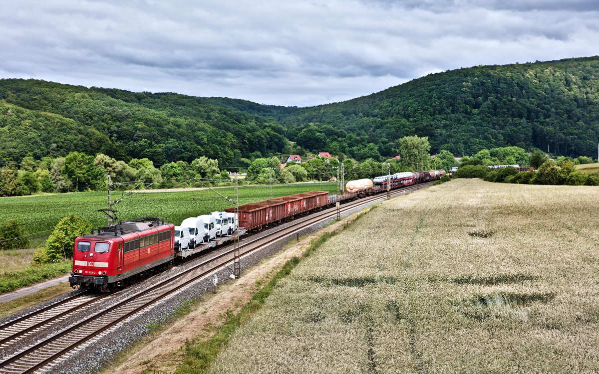 Die 151 012-2 fährt in Gambach mit einem gemischten Güterzug vorüber.Bild vom 17.6.2017