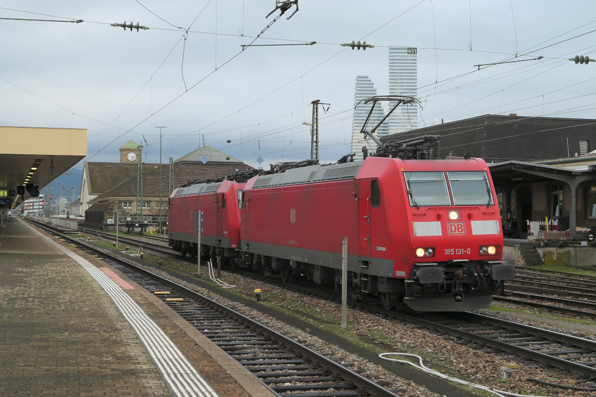 Die 185 131 und 185 123 der DB Cargo durchfahren den Bahnhof Basel Bad leer auf Gleis 1 Richtung Norden, Richtung Weil am Rhein. Im Hintergrund erkennt man die beiden Hochhäuser der Firma Roche Holding AG, die höchsten Häuser der Schweiz.
Basel Bad Bahnhof, 14.12.2023