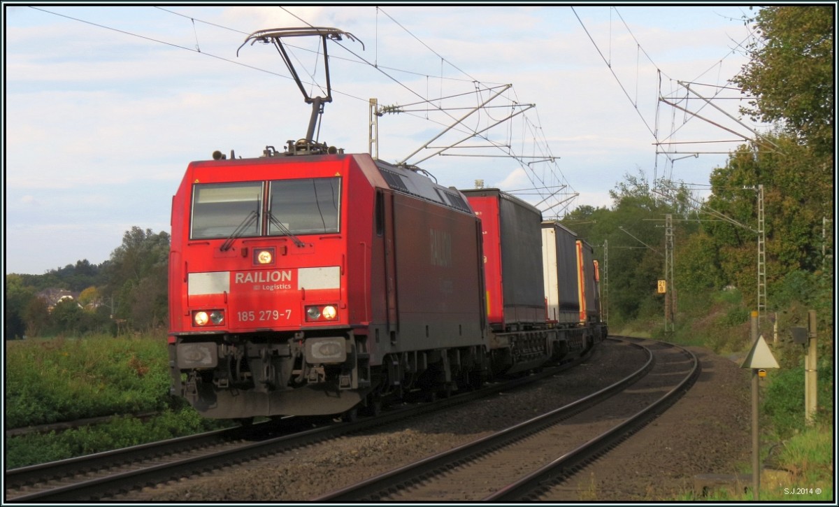 Die 185 279-7 ist mit einen Aufliegerzug (KLV) unterwegs nach Aachen. Hier zu sehen am BÜ in Rimburg auf der Kbs 485 am 11.Oktober.2014.