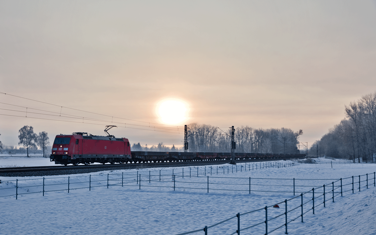 Die 185 348-0 fährt am frühen Morgen mit einem Stahlplattenzug in Langenisarhofen vorüber.Bild vom 19.1.2017