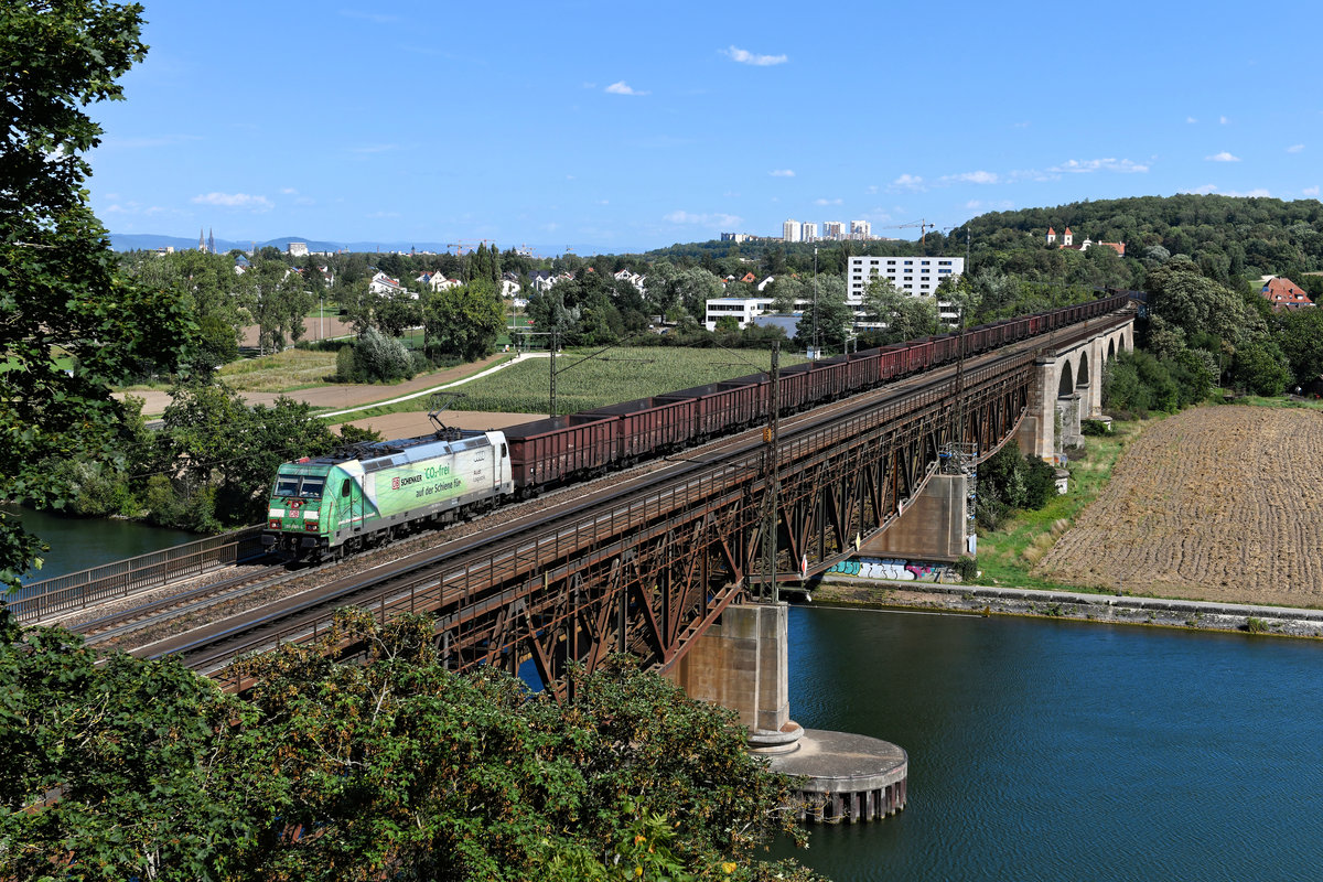 Die 185 389 wirbt seit geraumer Zeit für einen CO2-freien Verkehr auf der Schiene. Am 26. August 2020 war sie vor einem langen Ganzzug, bestehend aus tschechischen Eaos, auf der Donauachse zu beobachten. Mir gelang eine Aufnahme, als die Leistung geräuschvoll die Mariaorter Eisenbahnbrücke bei Regensburg überquerte. 
