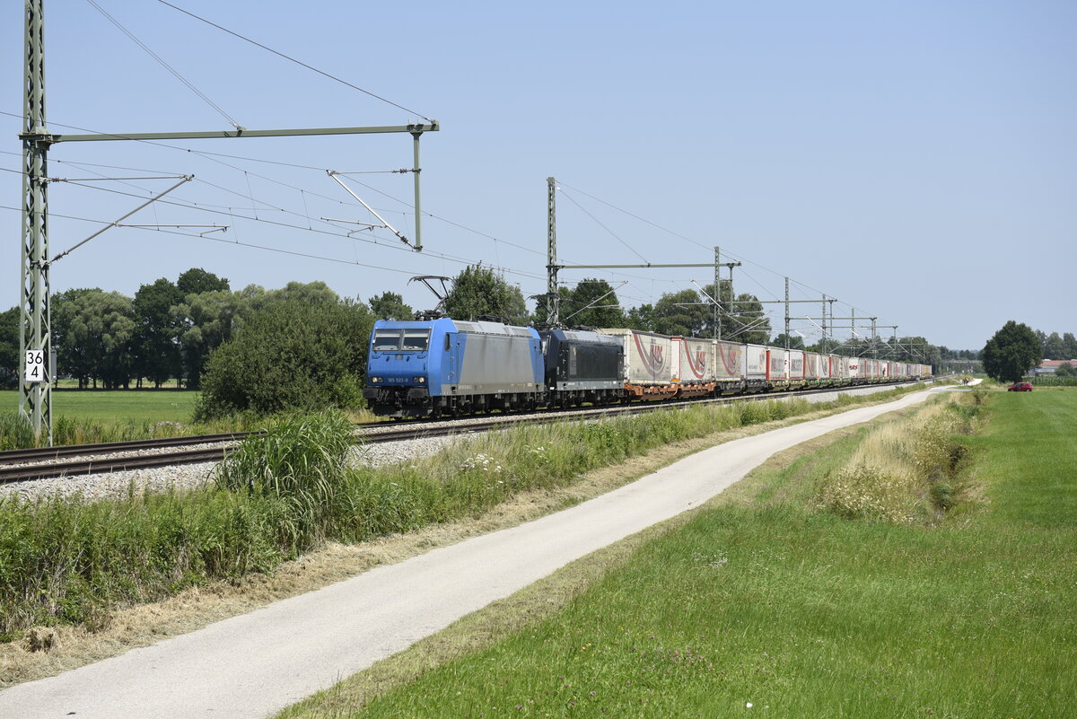 Die 185 523-8 von TX Logistik AG und Maschine der MRCE mit einem Taschenwagenzug der Spedition Mars auf der Strecke Salzburg in Richtung München kurz nach Übersee am Chiemsee. Aufgenommen am 22.07.21