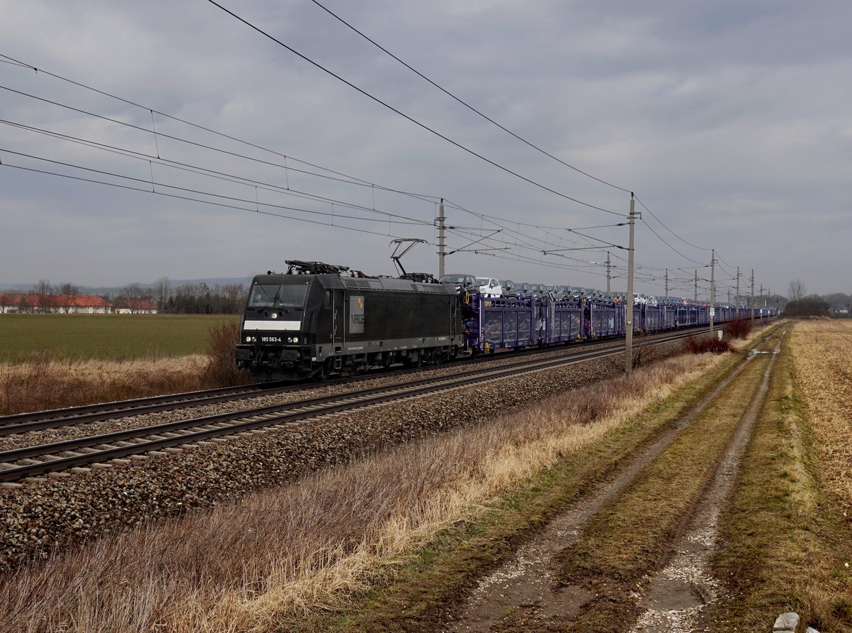 Die 185 563 mit einem Autozug am 11.03.2018 unterwegs bei Oftering.