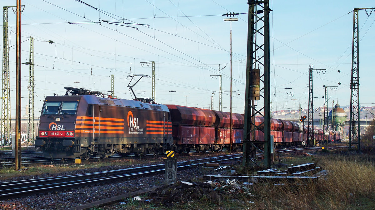 Die 185 601-2 der HSL mit einem Zug von Holcim Selbstentladewagen Typ Fals 33 85 6665 in Weil a. Rhein.
Weil a. R. am 22.11.17