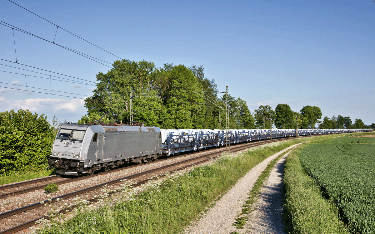 Die 185 621-0 fährt in Langenisarhofen mit einem Autozug voller Jeep Geländewagen vorbei.Bild vom 26.5.2016