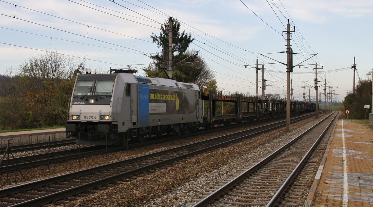Die 185 672-3 von Ruhrtalbahn Cargo ``Gut,Güter,Grenzenlos, auf Kaiser Karls Spuren durch Europa`` ist mit einem leeren Autotransportzug am 12.11.2014 durch Böheimkirchen Richtung Wien unterwegs.