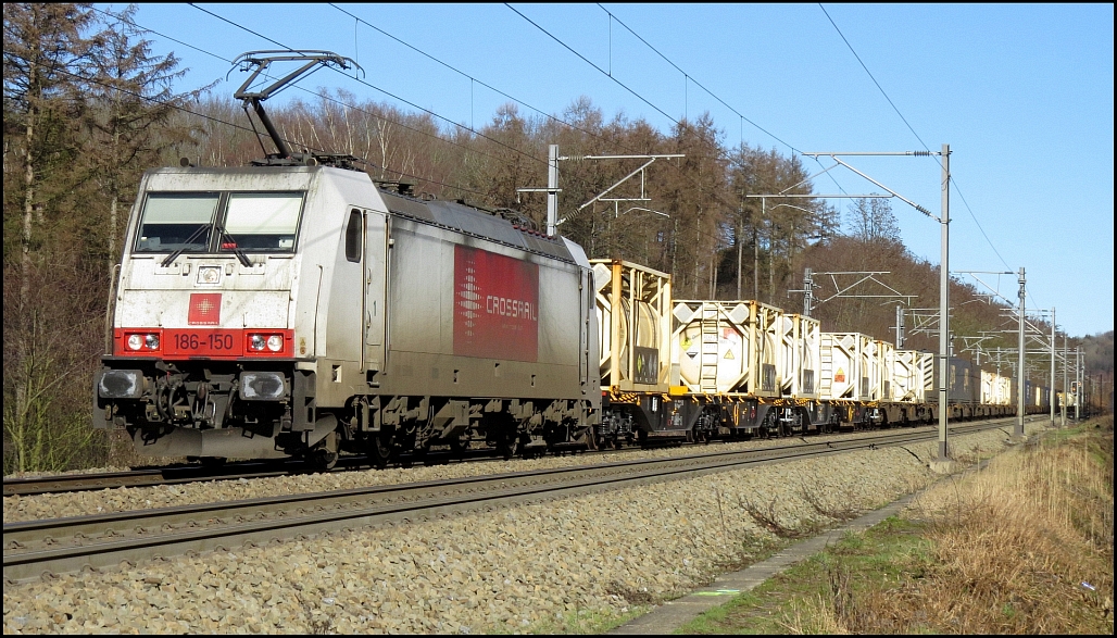 Die 186 150 der Crossrail Benelux ist mit ihrer Güterfracht in Richtung Montzen unterwegs, hier zu sehen im Wald bei Moresnet (B). 15.Februar 2019.