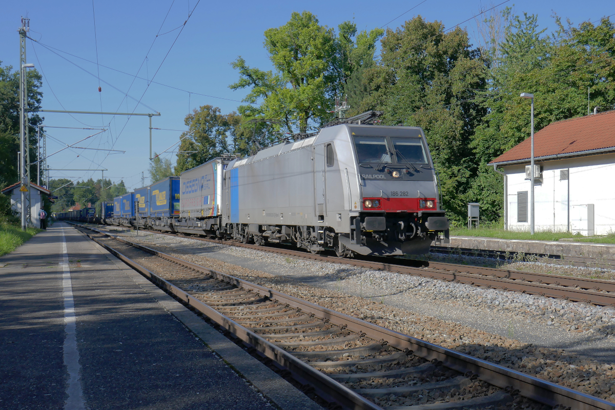 Die 186 282 durchfährt an einem sonnigen Donnerstag Nachmittag um 16.30 Uhr den Bahnhof Aßling auf ihrem Weg von München nach Italien. Im Schlepp hat sie einen langen Zug des kombinierten Ladungsverkehrs. 2. September 2021
