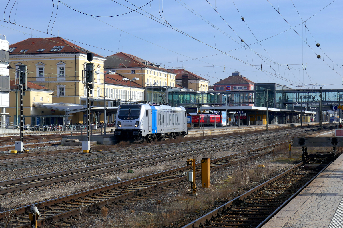 Die 187 303 des Münchner Lokomotiv-Vermieters Railpool erscheint geradezu klein vor dem imposanten Bau des Regensburger Hauptbahnhofs. 24. Februar 2022