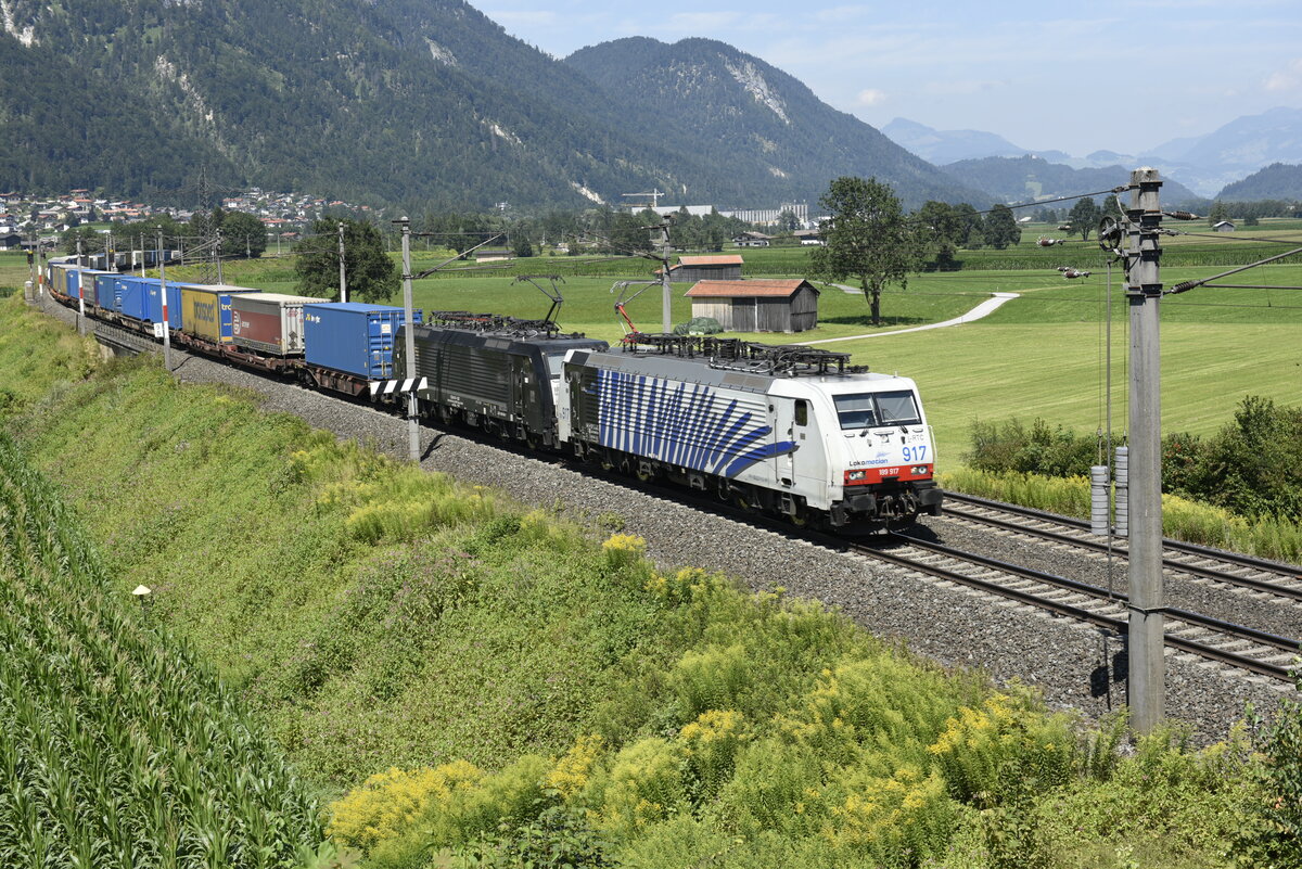 Die 189 917 von Lokomotion und eine Schwesterlok von MRCE auf der Inntalstrecke kurz nach Kufstein, nahe der Ortschaft Langkampfen in Richtung Brenner. Aufgenommen am 28.07.22