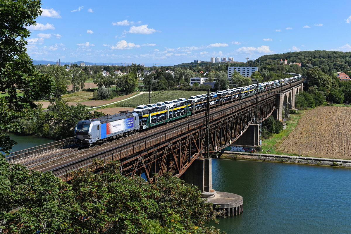 Die 193 994 von Railpool steht aktuell für die Rurtalbahn im Einsatz. Sie trägt eine Seitenwerbung für TankMatch Rail, einem Dienstleister aus Hamburg für den Transport und Lagerung von Mineralölprodukten, Flüssigchemikalien sowie nachhaltigen Flüssigprodukten. Am 26. August 2020 wurde der Vectron jedoch nicht für die Beförderung eines Kesselwagenzuges herangezogen, sondern für einen Neuwagentransport aus Ungarn nordwärts eingeteilt. Auf der Mariaorter Eisenbahnbrücke konnte ich die Leistung aufnehmen.