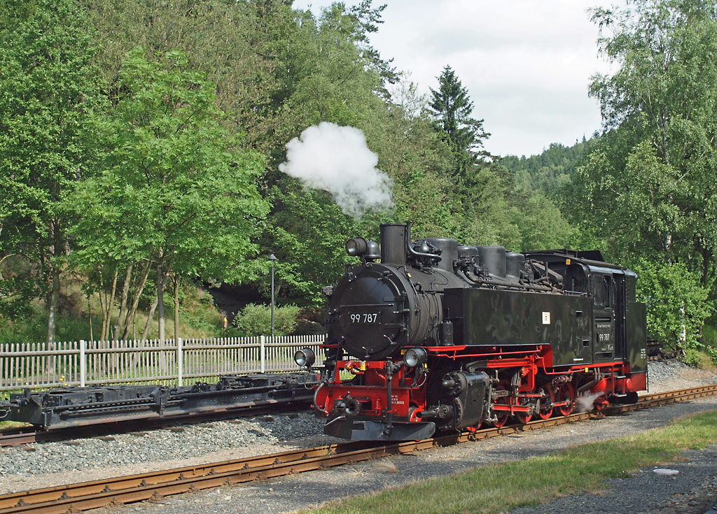 Die 1955 in Babelsberg gebaute 99 787 setzt am 17.06.2014 gerade in Oybin ans andere Zugende um, nachdem sie den langen Zug 202 gerade aus Zittau herauf gebracht hat, hat sie noch den Wasservorrat aufgefüllt (im Gegensatz zum Endbahnhof des anderen Streckenasts in Johnsdorf gibts es in Oybin einen Wasserkran) und wird dann den als Nr. 203 geführten Zug zurück nach Zittau führen. 