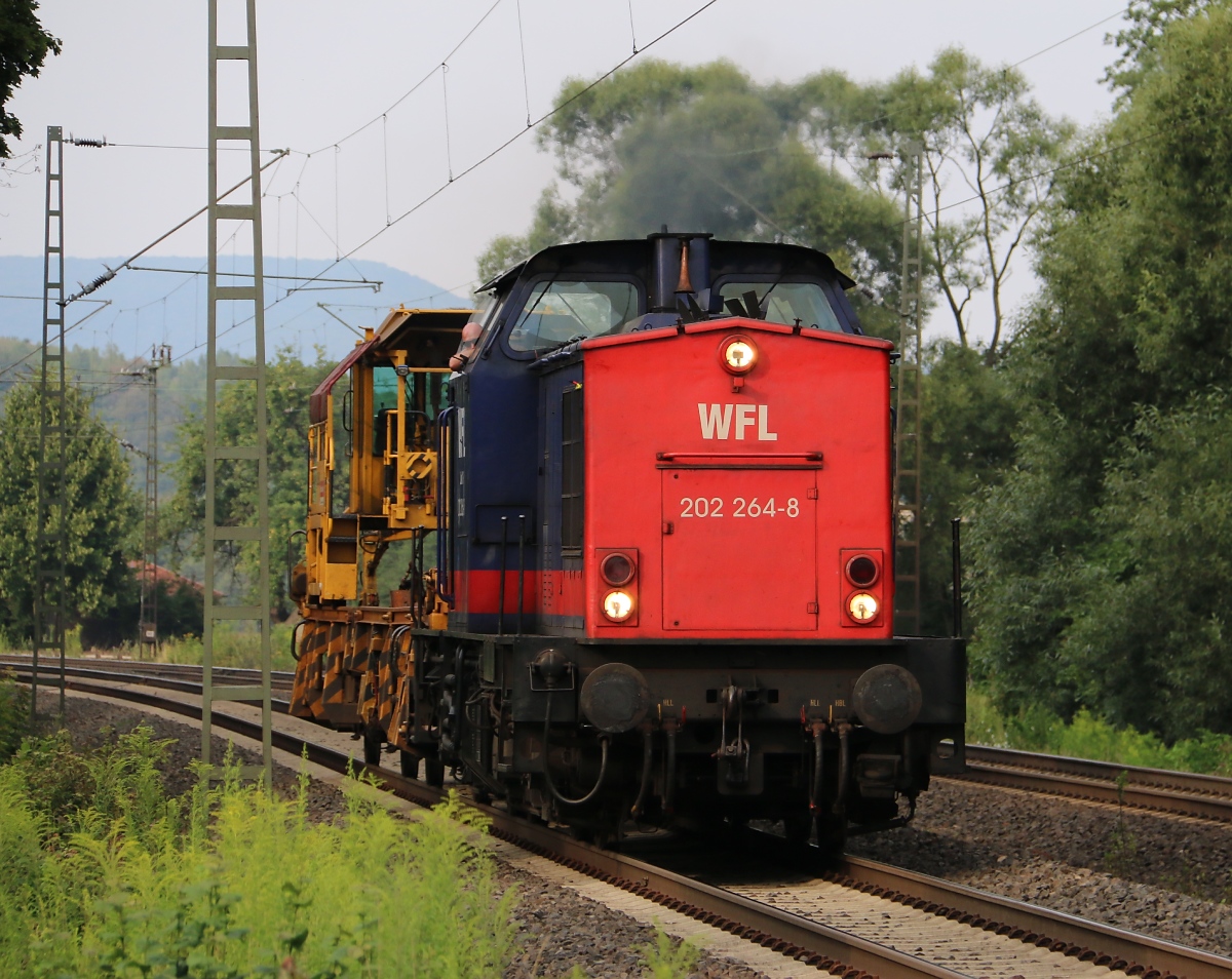 Die 202 264-8 der WFL kam am 27.07.2014 mit einer Baumaschine im Schlepp in Richtung Süden durch Wehretal-Reichensachsen.