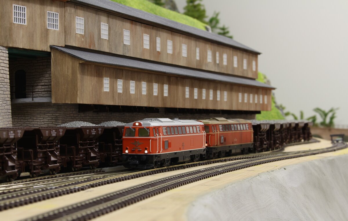 Die 2043.55 und 2043.58 stehen im Herbst 1978 mit einem beladenen Erzhalbzug neben der gewaltigen Erzverladeanlage im Bahnhof Erzberg und warten auf die Abfahrt nach Vordernberg Süd wo der Zug von einer 1245er nach Donawitz gebracht wird.