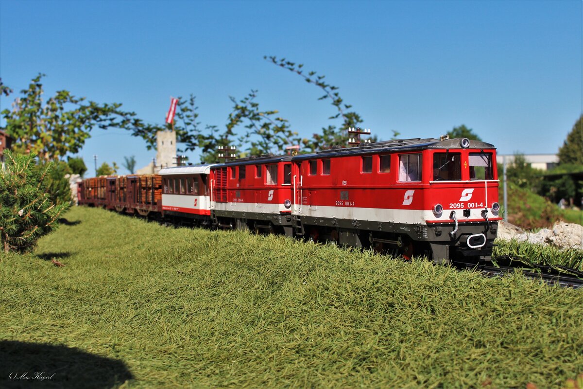 Die 2095 001 und die 2095 004 haben mit einem Verschubgüterzug Richtung Garting den Bahnhof Strauchbach verlassen und rollen gemütlich ihrem Ziel entgegen.
Die Doppeltraktion ist auf der steigungsreichen Strecke für das hohe Frachtaufkommen essentiell.
Bild vom 14.8.2023