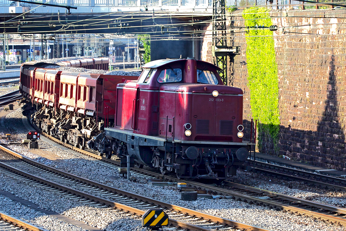 Die 212 133-3 dieselt mit einem Schotterzug durch Offenburg.Bild vom 6.8.2015