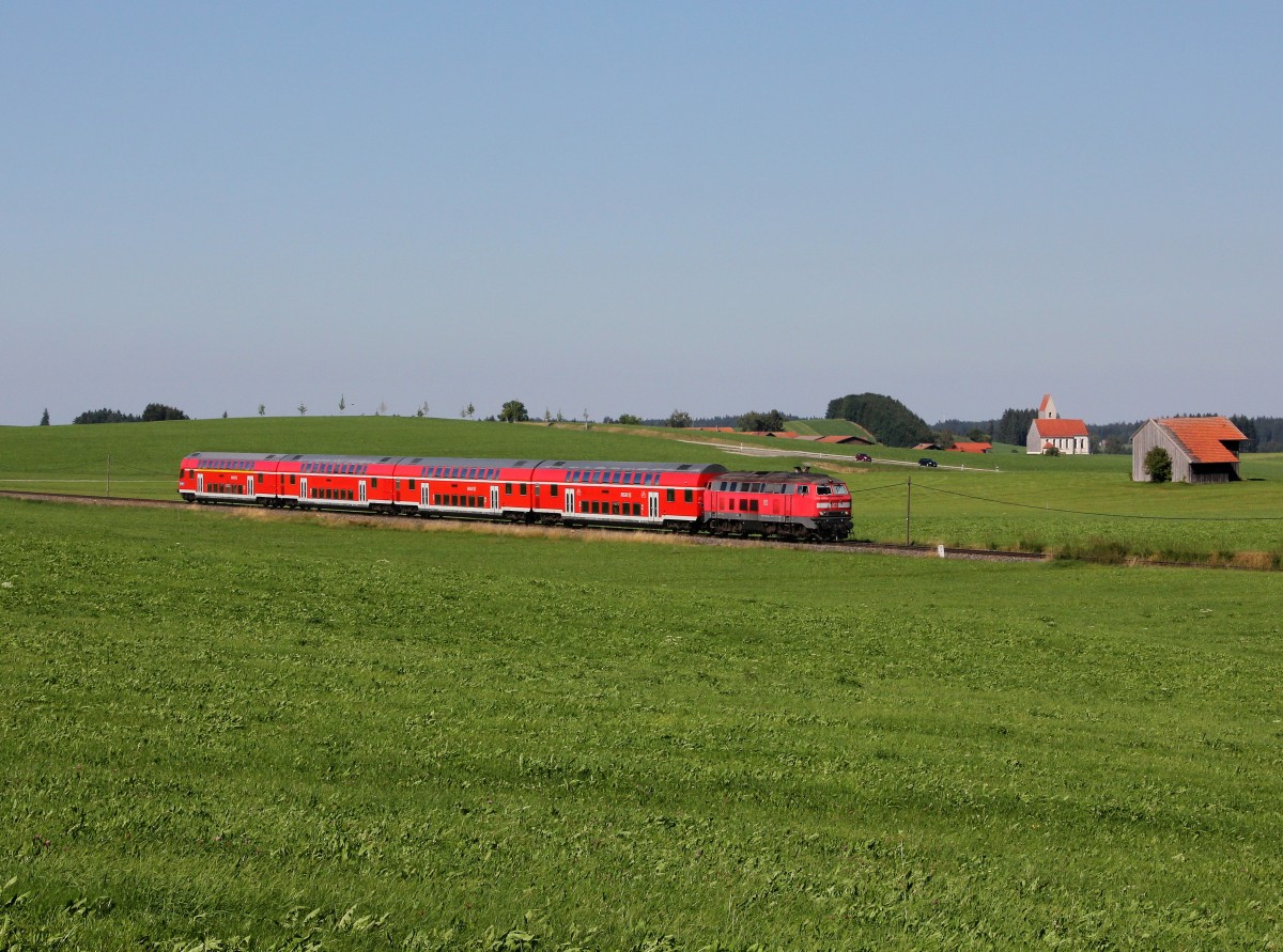 Die 218 420 mit einem RE nach Füßen am 30.08.2015 unterwegs bei Seeg.