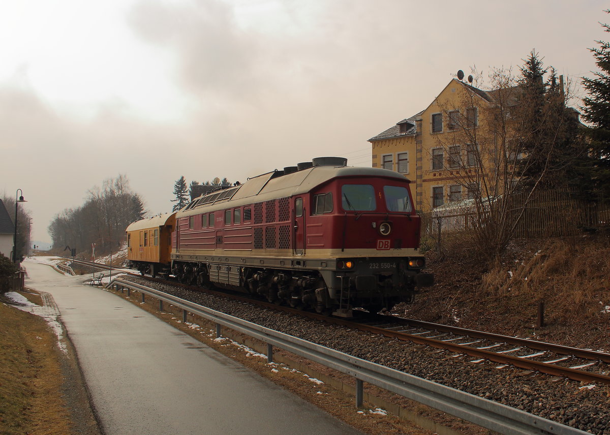 Die 232 550 mit einem Bauzugwaggon auf der Mehlbahn Richtung Gera. Aufgenommen am 03.03.2018 in Bernsgrün. 
