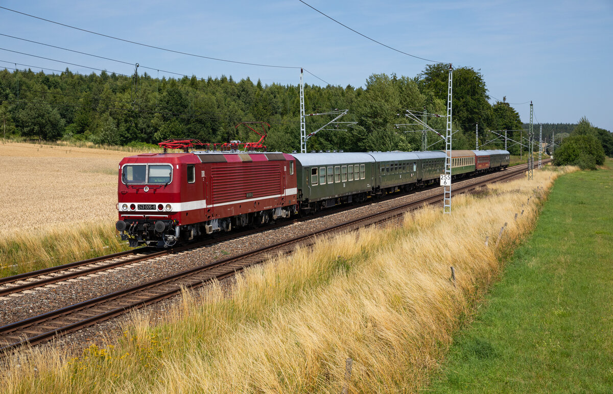 Die 243 005 zog ihren Leereisezug am 15.07.2023 vom Ostseebad Binz nach Bergen, kurz vor dem Ziel durch Strüßendorf.