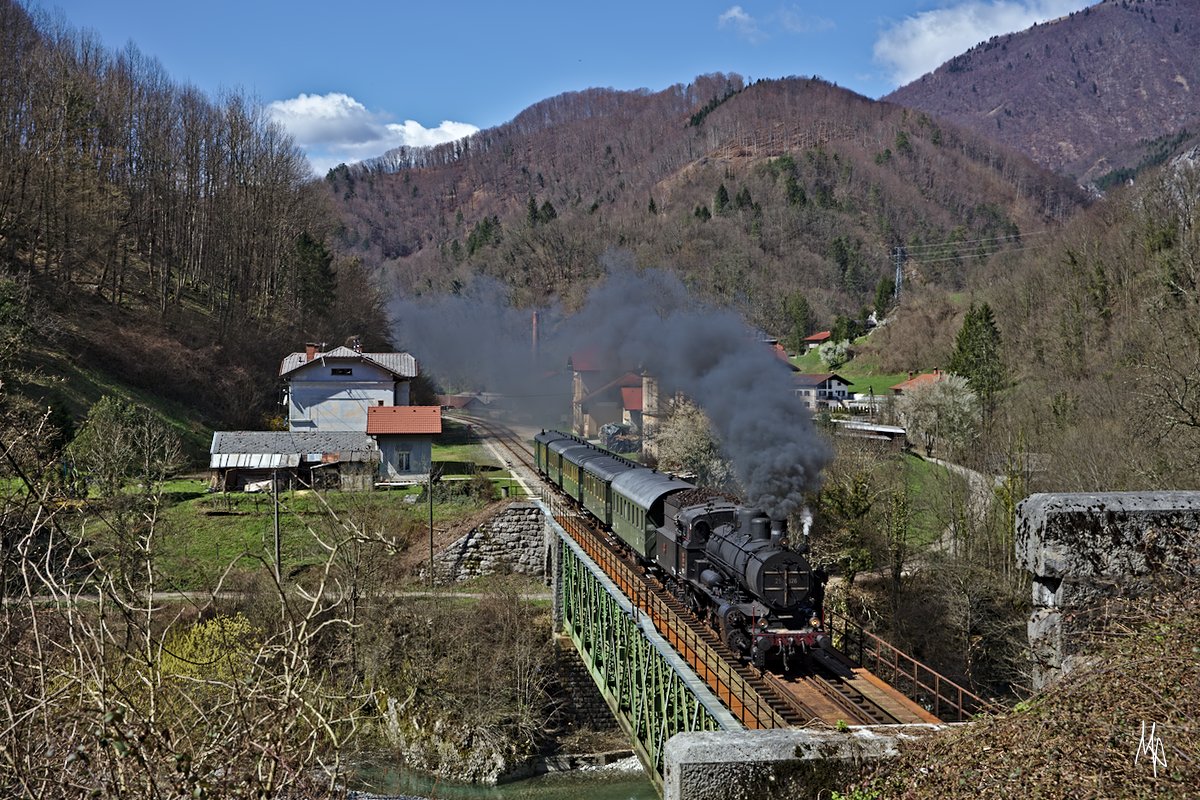 Die 25.026 verlässt gerade mit ihrem ausschließlich für Fotografen in Bewegung gesetzten stilechten Sonderzug diese Haltestelle Podmelec und fällt fährt gleich in einen der zahlreichen Tunnel ein. (06.04.2018)