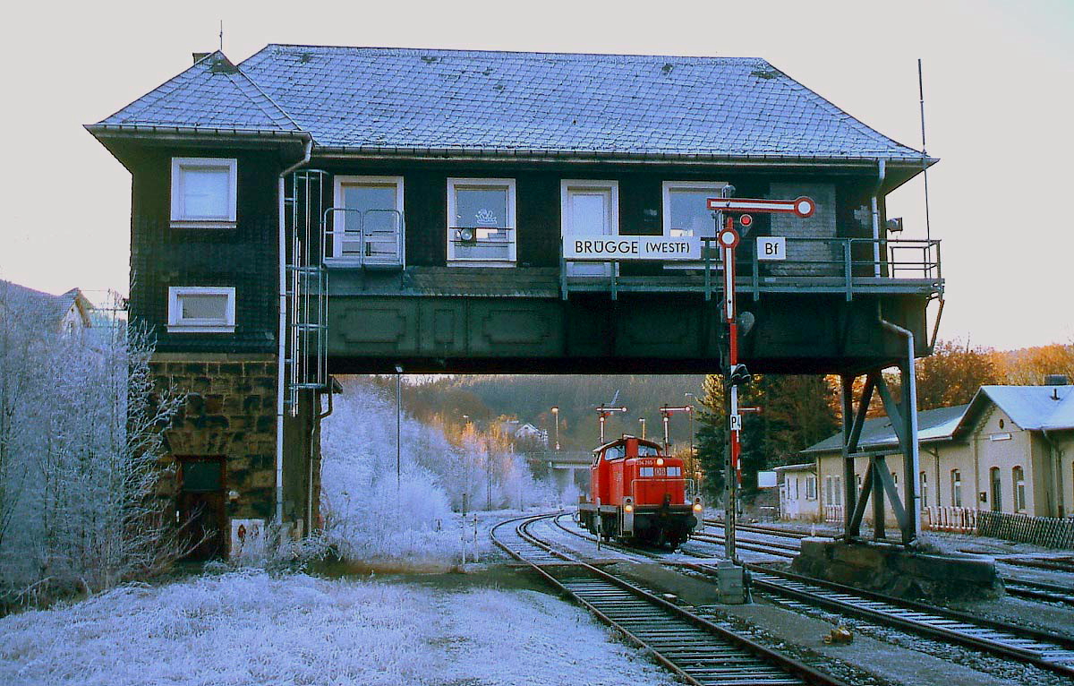 Die 294 245-1 wartet im Dezember 2003 im Bahnhof Brügge (Westfalen) auf den nächsten Einsatz. An den kürzesten Tagen des Jahres kommt die Sonne nicht bis hierhin ins Tal und so sind Gleise und Buschwerk auch am Nachmittag noch raureifbedeckt.