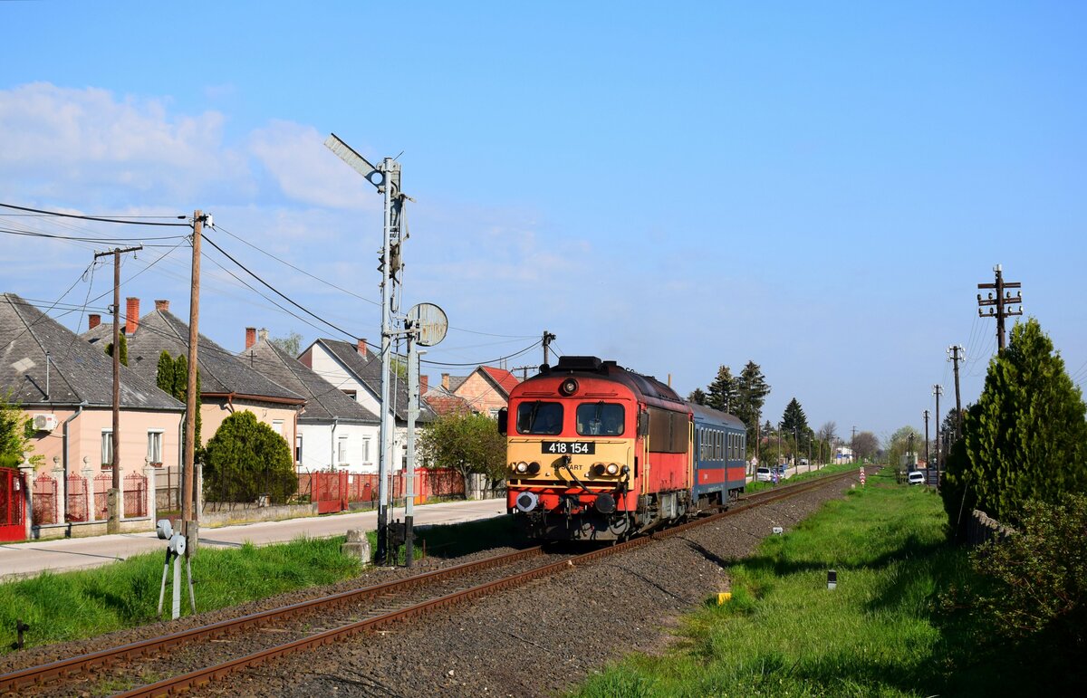 Die 418 154 (ex. M41 2154) mit dem Personenzug 34917 (Komárom - Székesfehérvár) bei der Einfahrtsignal von Kisbér. Das war Ersatzgarnitur statt Bzmot Triebwagen.
Kisbér, 23.04.2023.