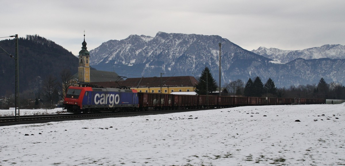 Die 482 045-2 der SBB Cargo, angemietet von Lokomotion, zieht am 18.12.2013 den leeren Schrottzug von Italien nach München, hier bei Niederaudorf. Im Hintergrund das Kaisergebirge.