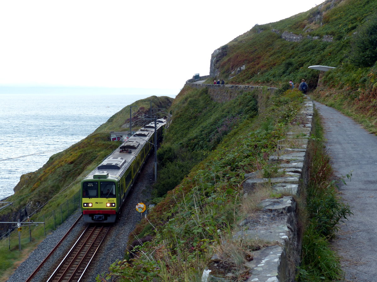 Die 6 Kilometer lange Wanderstrecke zwischen Bray und Greystones ist sehr beliebt - und nicht wenige Kinder wollen hier und da warten, um den Zug aus dem Tunnel fahren zu sehen. DART #8629 in RIchtung Malahide am 6.8.2017 nahe Bray