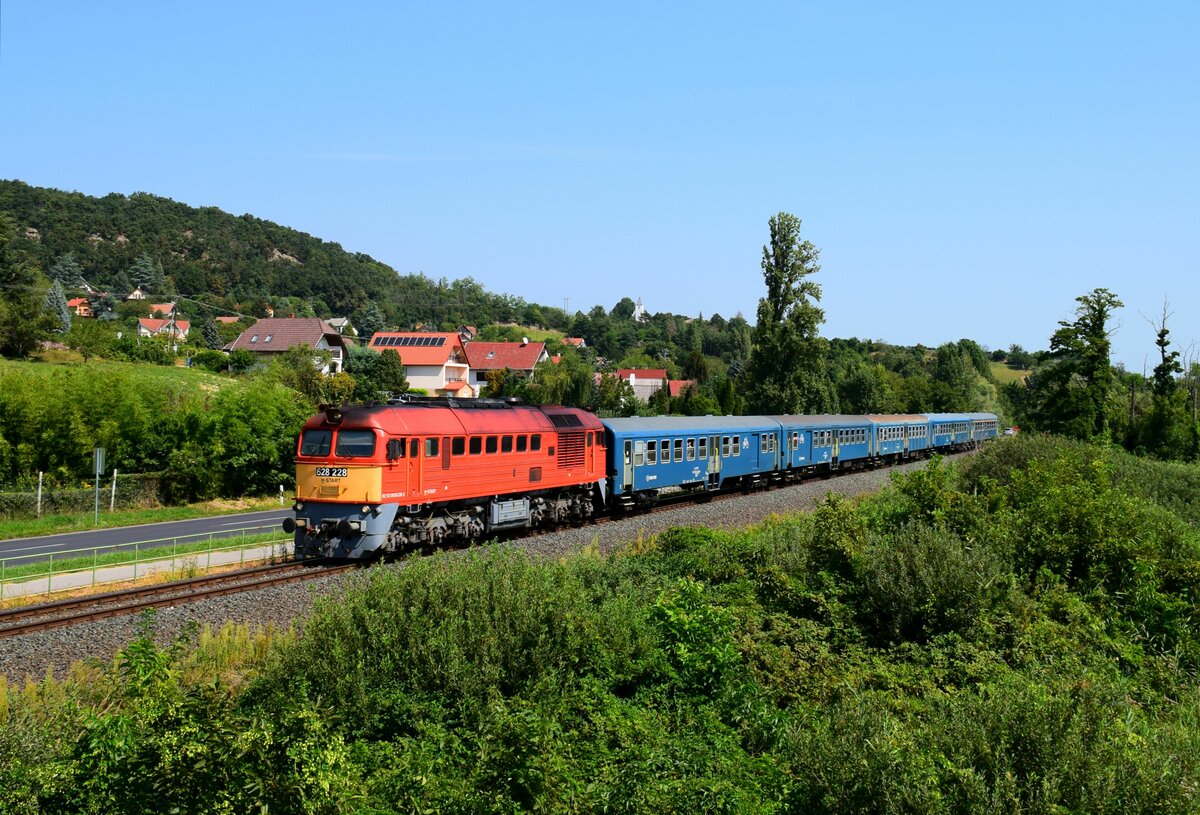 Die 628 228 (ex. M62 228) ist mit dem Zug 19774 (Balatonfüred-Tapolca) unterwegs kurz vor Hst. Badacsonyörs.
27.08.2023.