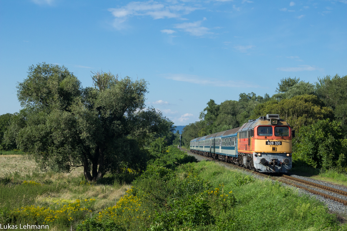 Die 628 320 Taiga-Trommel mit ihrem Schnellzug in Richtung Budapest steht kurz davor den Bahnhof Badacsonytördemic-Szigliget zu durchfahren, 11.08.2016
