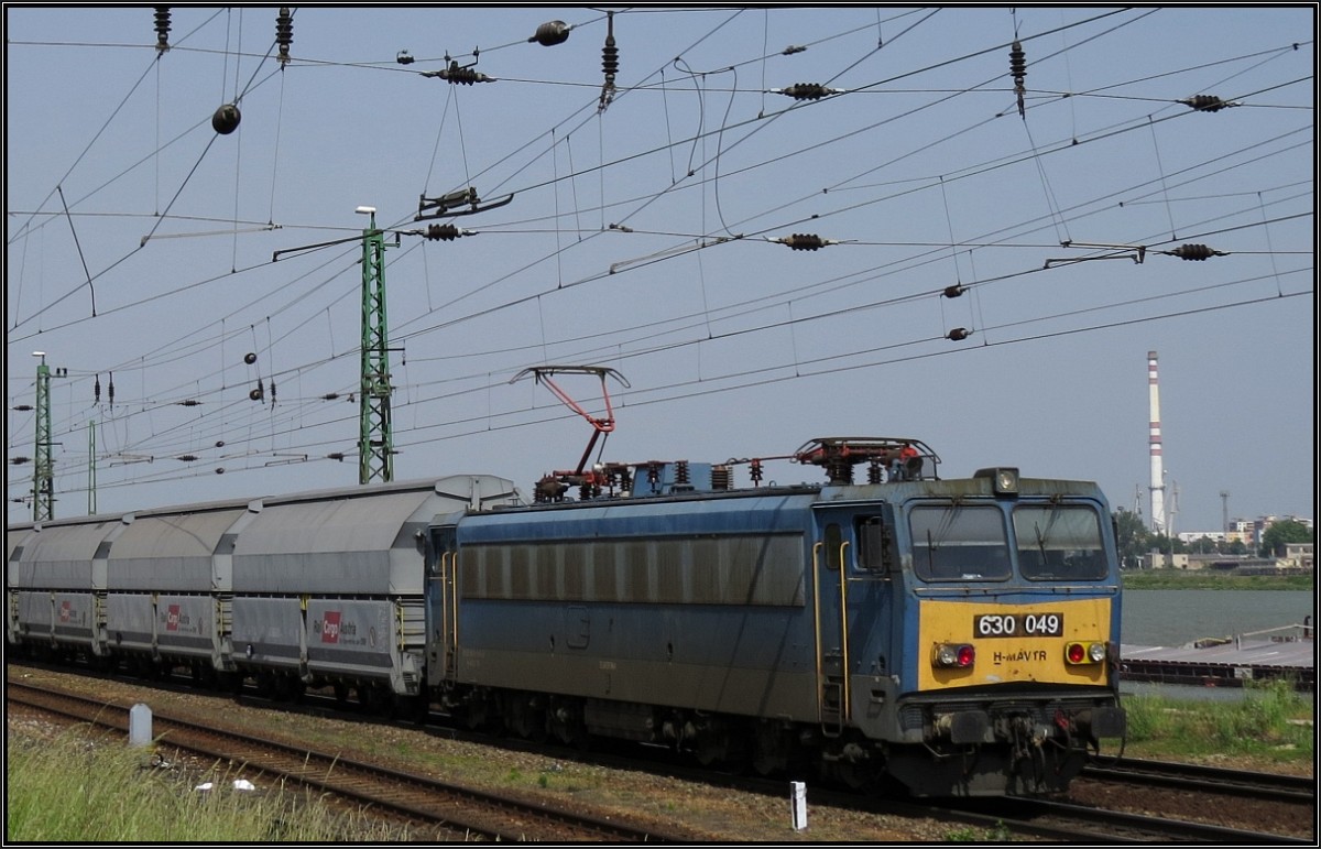 Die 630 049 (V 63) der MAV ist mit einen Schüttgutwagenzug der Rail Cargo Austria unterwegs auf der Kbs 1 am Donauufer bei Komárom (Ungarn). Szenario vom 20.Mai 2014.