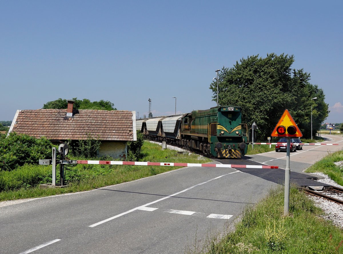 Die 664 102 mit einem Getreidezug  am 27.06.2020 bei der Ausfahrt in Središče.