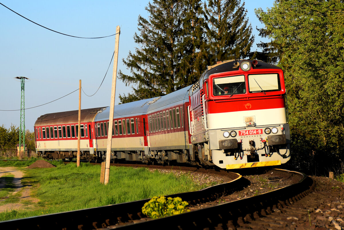 Die 754 014 (Okuliarnik - Taucherbrille) mit dem Personenzug 4362 von Komárno nach Dunajská Streda kurz vor Nová Stráž. Nová Stráž, 30.04.2021.