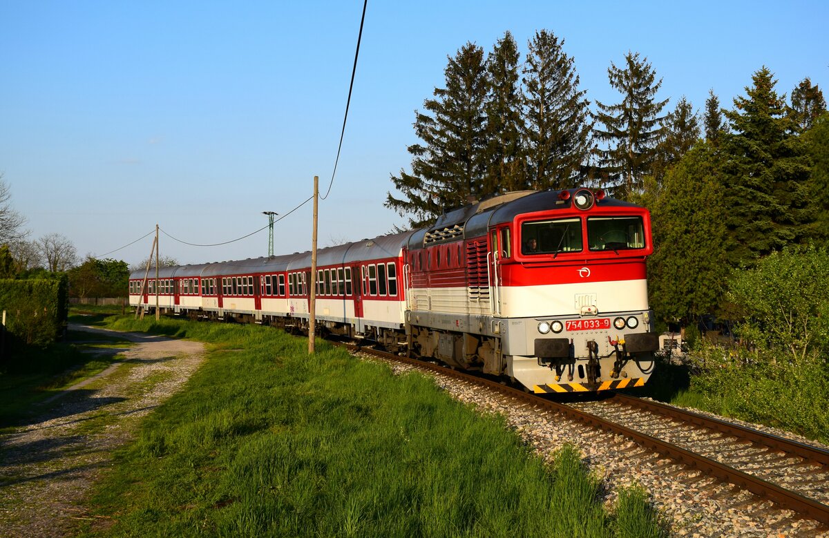 Die 754 033-er Taucherbrille ist auf dem Weg von Komárno (Komárom) nach Dunajská Streda (Dunaszerdahely) kurz vor Komárno Nová Stráž (Örsújfalu) mit dem Zug Os4342. 
27.04.2023.