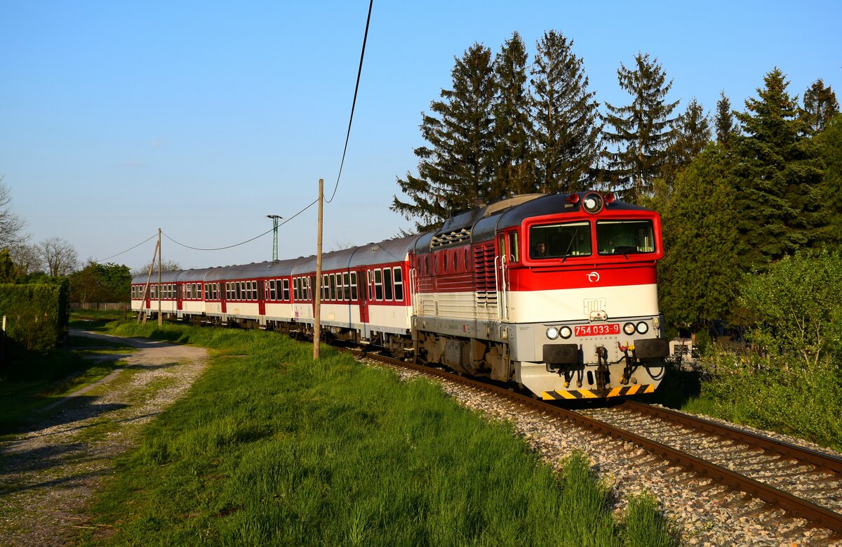 Die 754 033-er Taucherbrille ist auf dem Weg von Komárno (Komárom) nach Dunajská Streda (Dunaszerdahely) kurz vor Komárno Nová Stráž (Örsújfalu) mit dem Zug Os4342. 
27.04.2023.