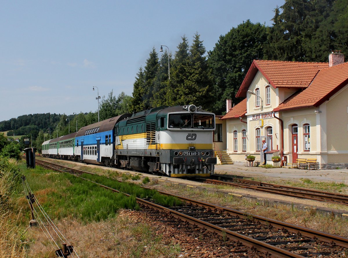 Die 754 045 mit einem Os nach České Budějovice am 18.07.2015 bei der Ausfahrt aus Zlatá Koruna.