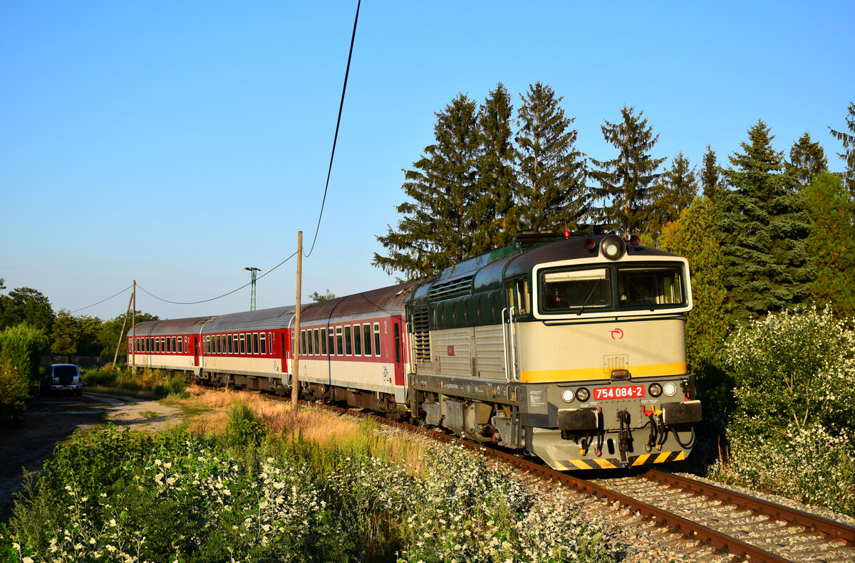 Die 754 084-er Taucherbrille mit dem Abendzug 4370 von Komárno (Komárom) nach Dunajská Streda (Dunaszerdahely, Niedermarkt) kurz vor Hst. Komárno Nová Stráž (Örsújfalu).
17.08.2022.