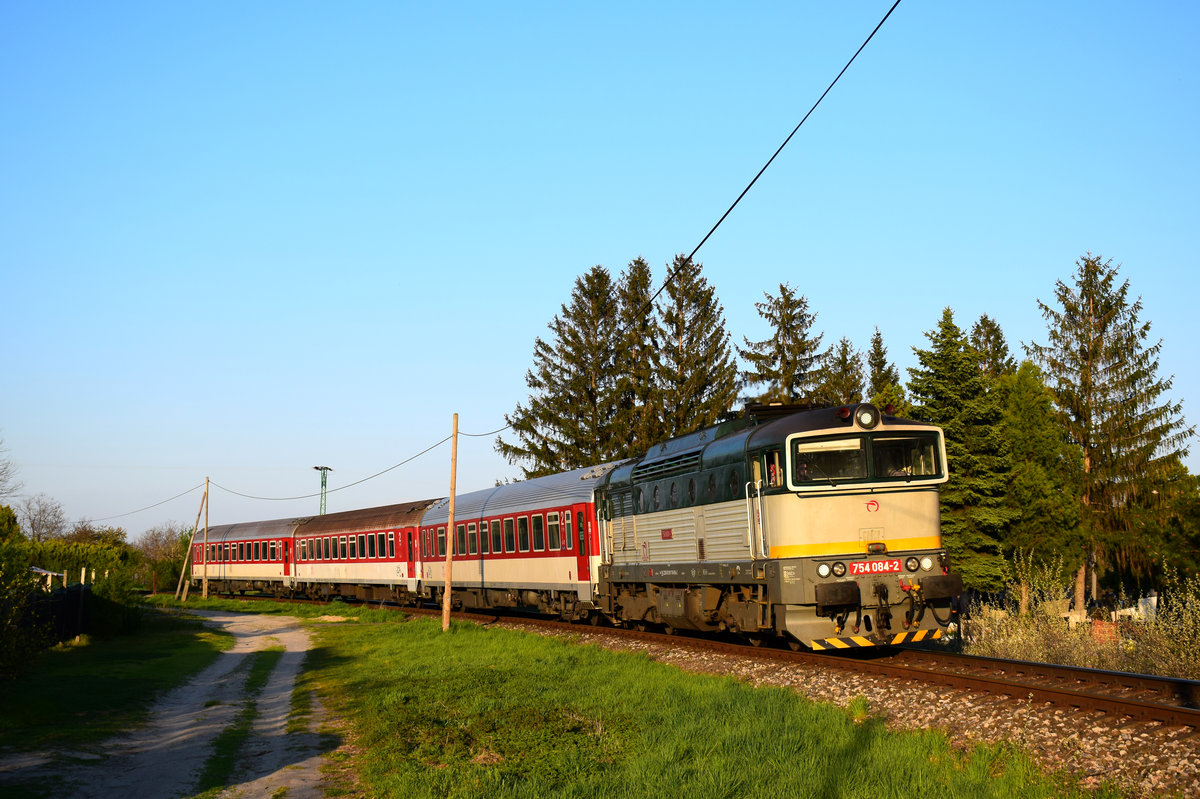 Die 754 084 (Okuliarnik - Taucherbrille) mit dem Personenzug 4362 von Komárno nach Dunajská Streda kurz vor Nová Stráž.
Nová Stráž, 23.04.2021.