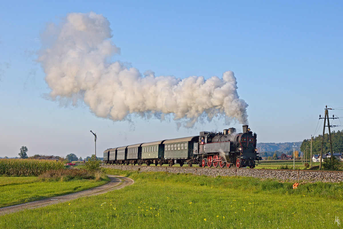 Die 77.28 bei der Einfahrt in Munderfing, wo glücklicher Weise die alten Formsignale noch vorhanden sind. Links in Hintergrund sieht man die Kirche von Mattighofen. (08.10.2021)