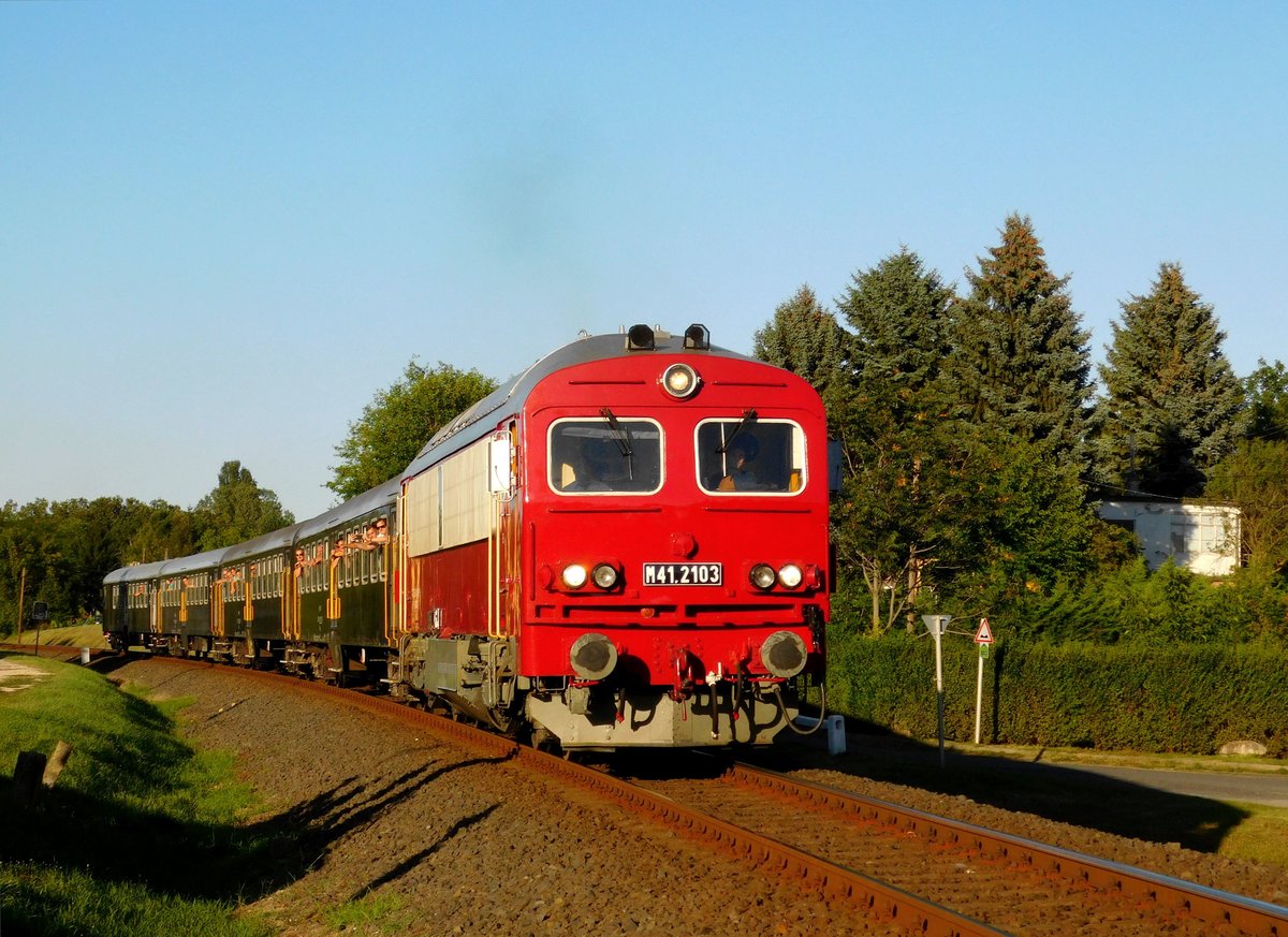 Die älteste M41 ist die 2103-er. Die retrolackierte Lok ist mit einem retrolackierte Zug von Balatonfüred nach Tapolca bei Ábrahámhegy unterwegs.
Das schöne Abendfoto ist von meines Sohn Márk Németh.
Ábrahámhegy, 01.08.2020.