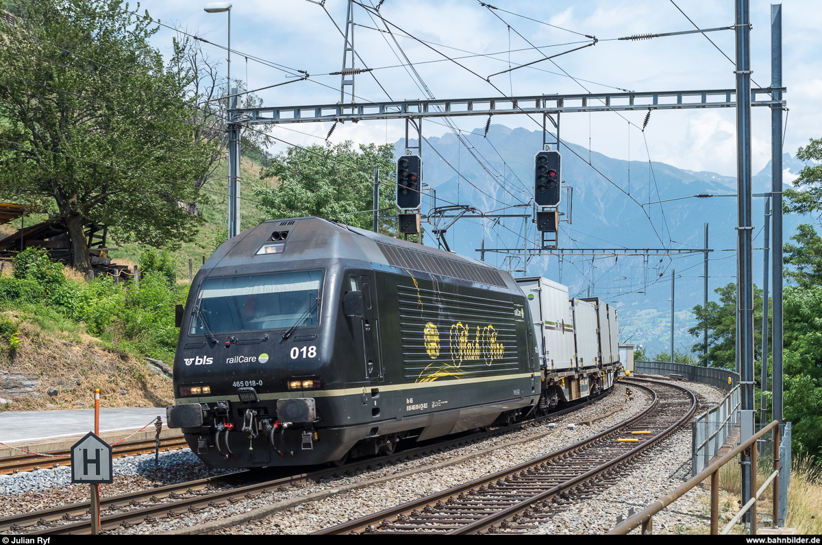 Die an RailCare vermietete BLS Re 465 018  Flash Fire  durchfährt am 24. Juni 2017 den Bahnhof Lalden auf dem Weg von Brig nach Niederbottigen.
RailCare erhält im Herbst diesen Jahres 7 eigene Vectron. Die Einsätze der BLS Re 465 für RailCare werden also schon bald enden.
